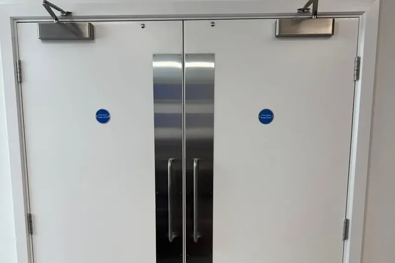 Double fire doors with overhead closers, push plates and keep shut signs in a managed building