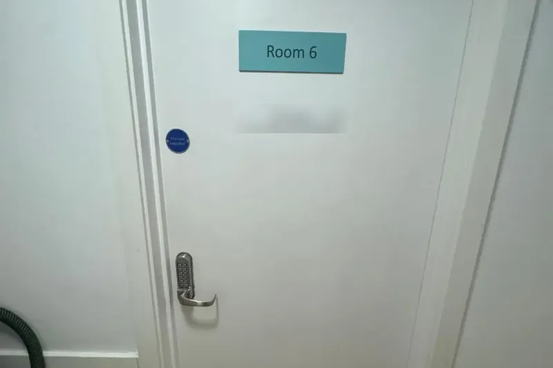 White consulting room fire door with keypad lock, kick plate and keep shut sign