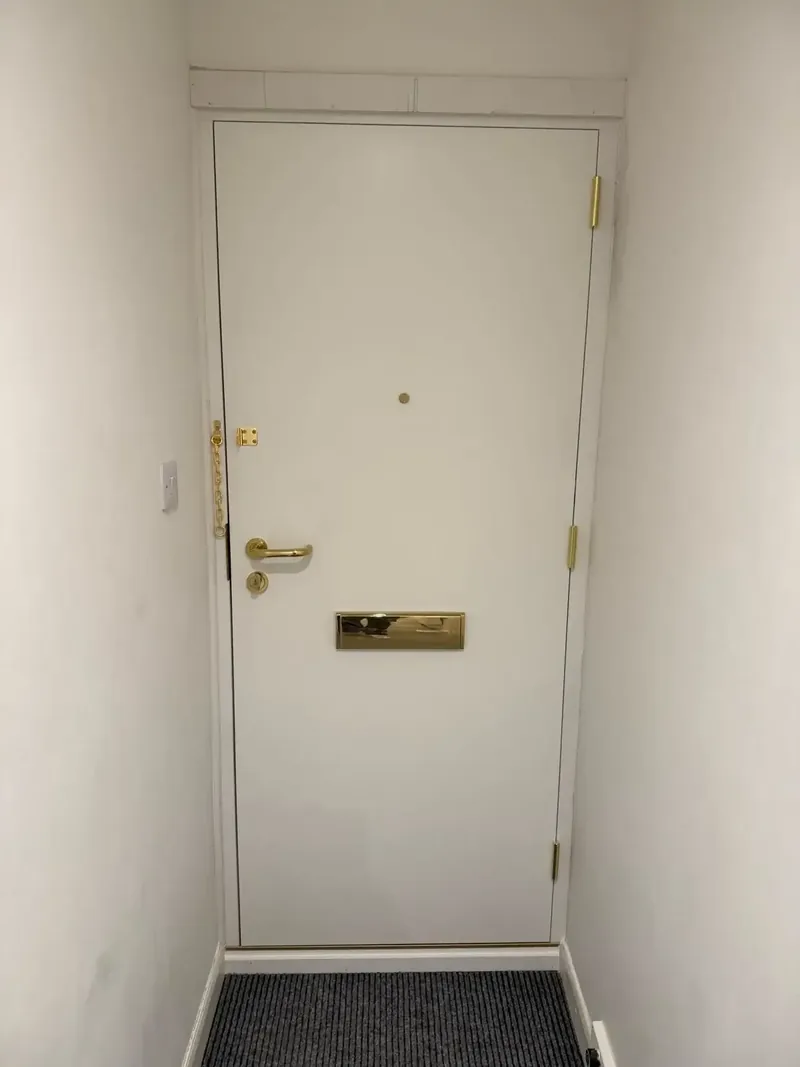 Residential fire door showing certified hinges and letterplate